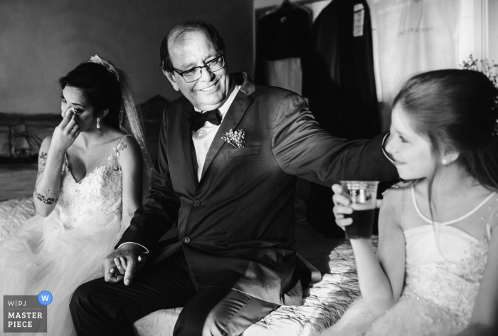 Foto: <a href="https://www.wpja.com/contests/2019-v14/best-wedding-photographers/2553477"> Bruno Montt - Rio de Janeiro Rio de Janeiro </a> Solar da Palmeiras - Ilhada Gigóia / RJ - Brasilien Hochzeitsfotojournalismus - Der Vater erlebt einen einzigartigen und aufregenden Moment: Händchenhalten mit seiner Tochter, um eine weitere Familie zu gründen. Auf der anderen Seite seine andere Tochter, so jung und voller Leben.