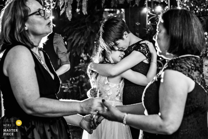 Photo by: <a href="https://www.wpja.com/contests/2019-v14/best-wedding-photographers/2553610">Michelle Arlotta - Milford New Jersey</a> The Gables Inn, Long Beach Island, New Jersey Wedding Photography - Two young ladies hug while dancing at The Gables Inn LBI NJ