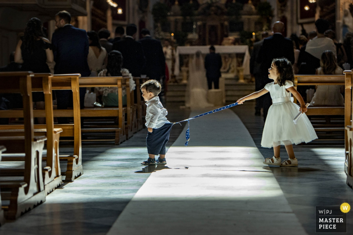 Photo by: <a href="https://www.wpja.com/contests/2019-v14/best-wedding-photographers/2553973">Pasquale Minniti - Reggio Calabria</a> Ragusa Wedding Photography Award - children play in church during the ceremony for the bride and groom