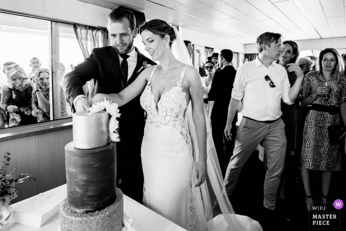 Photo: <a href="https://www.wpja.com/contests/2019-v14/best-wedding-photographers/2553987"> Freek Nagtzaam - 's-Hertogenbosch Noord Brabant </a> Photographie de découpage de gâteaux de Rotterdam en noir et blanc - photojournalisme de mariage