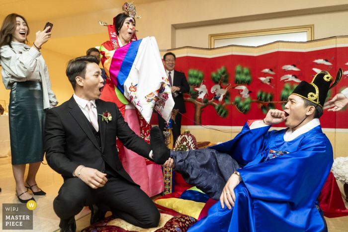 Biltmore Ballrooms Atlanta Wedding Venue Photographer - Groomsman smacking the grooms feet to test his commitment 