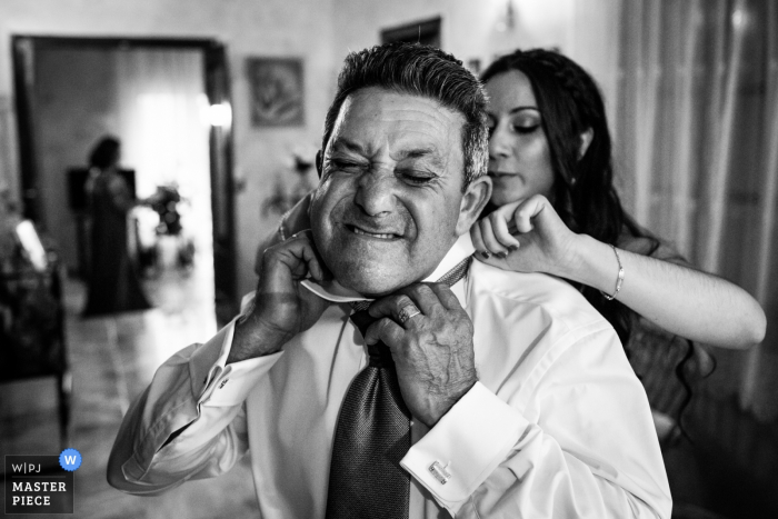 Groom's father tightening his tie Spain Getting ready photography of the Groom's father tightening his tie