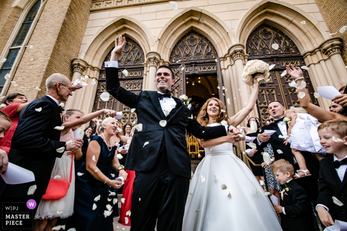Photo by: <a href="https://www.wpja.com/contests/2019-v14/best-wedding-photographers/2554220">Milan Lazic - Chicago Illinois</a> Holy Family Catholic Church - Wedding ceremony photography with bride and groom and flower petals flying