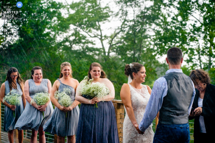 Photo by: <a href="https://www.wpja.com/contests/2019-v14/best-wedding-photographers/2554227">Johnny Shryock - Arlington Virginia</a> Rixey Manor, Rixeyville, VA Outdoor Wedding Venue Photos - Bridesmaids are surprised by the wind and rain during the wedding ceremony