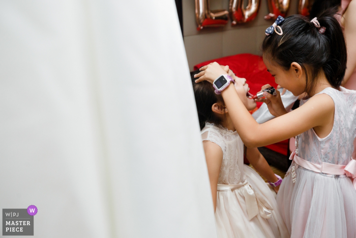 Photo by: <a href="https://www.wpja.com/contests/2019-v14/best-wedding-photographers/2554279">Joy Qin - Longyan </a> Fujian, China Wedding Photojournalism - Flower Girls putting on Lipstick