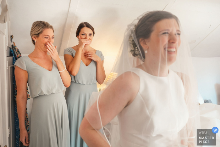 the bride with her dress on and as she took a first look at herself in a full length mirror with her bridesmaids behind her. East Midlands Wedding Photographer: I took this just after the bride had got her dress on and as she took a first look at herself in a full length mirror with her bridesmaids behind her. - Brides parents house