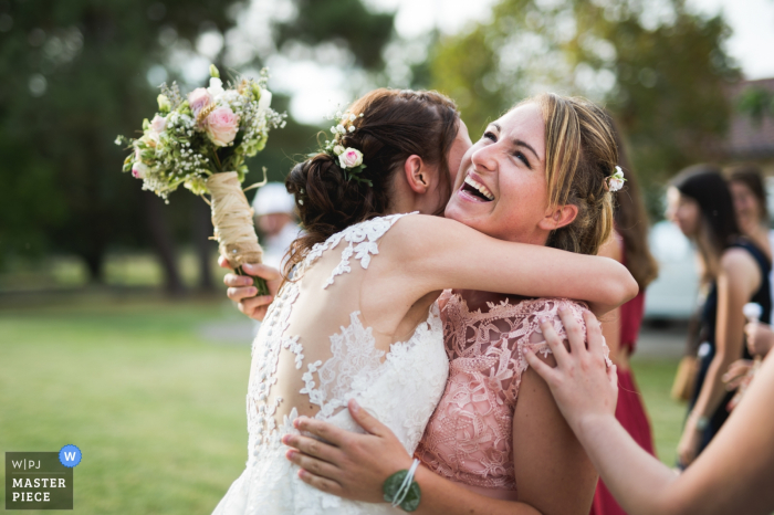 Photo by: <a href="https://www.wpja.com/contests/2019-v15/best-wedding-photographers/2555720">Franck Petit - Serignac sur Garonne </a> Nouvelle-Aquitaine wedding photography for Seyches, France - bride and bridesmaid hug after toss of bouquet