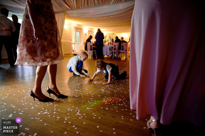Kids are being kids, picking the confetti England Reception venue photography — Kids are being kids, picking the confetti