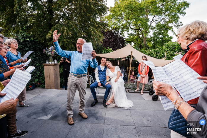 Foto von: <a href="https://www.wpja.com/contests/2019-v15/best-wedding-photographers/2555823"> Jola Mulder - Deurningen Overijssel </a> Niederländischer Hochzeitsfotograf - Im Garten von diesem Paar! Die Braut leitet ihren gewonnenen Chor und diese Gruppe sang ein Lied für sie!