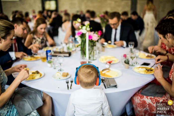 Photo by: <a href="https://www.wpja.com/contests/2019-v15/best-wedding-photographers/2556482">Matouš Bárta - Prague </a> Brickhouse wedding venue photographer — kid with the headphones during the reception meal