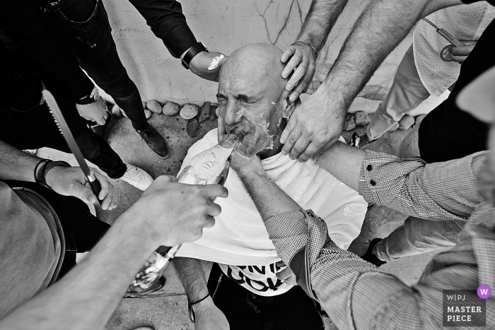 Photo by: <a href="https://www.wpja.com/contests/2019-v15/best-wedding-photographers/2557051">Robert David - Bucharest </a> Bucharest wedding photograph of the groom receiving lots of help while getting ready for his wedding.