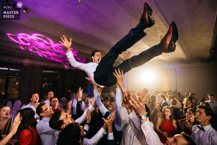 Vlaanderen trouwreceptie locatie fotografie Bruidegom wordt tijdens het feest in de lucht gegooid