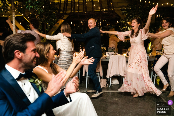 Photo by: <a href="https://www.wpja.com/contests/2019-v15/best-wedding-photographers/2557325">Yves Schepers - Bonheiden Antwerpen</a> Flanders Wedding Reception Photography | Bride and groom cheer their guests while they're doing a crazy conga