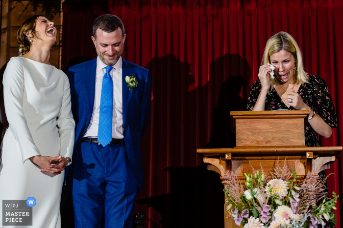 Photo by: <a href="https://www.wpja.com/contests/2019-v15/best-wedding-photographers/2557465">Sarah V. Martinez - Dover New Hampshire</a> Little Cranberry Island Maine at the Islesford Congregational Church — wedding photography — Tears from the speaker and laughter from the bride on the rainy island wedding day in Maine