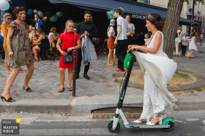 paris wedding photographer — bride arriving at reception venue on electric scooter rental