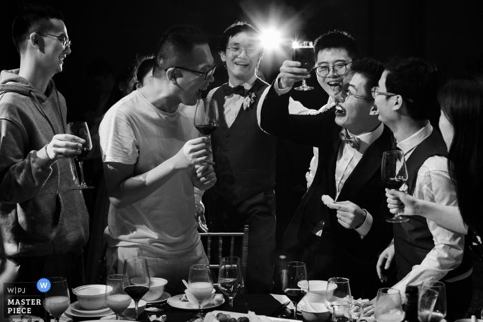 Foto: <a href="https://www.wpja.com/contests/2019-v15/best-wedding-photographers/2557490"> Vincent Mu - De Zhou </a> Fotografie des Hochzeitsempfangs im China Hotel - Der Bräutigam lachte über ein großes Glas Rotwein, das seine Freunde während des Toasts zubereiteten