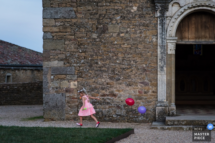 Photo by: <a href="https://www.wpja.com/contests/2019-v16/best-wedding-photographers/2560411">Coralie Castillo - Vernaison </a> Auvergne-RhĂ´ne-Alpes wedding photography | The little girl playing with balloons