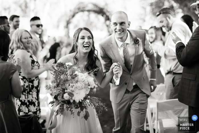 Photo by: <a href="https://www.wpja.com/contests/2019-v16/best-wedding-photographers/2560837">Carl Bower - Denver Colorado</a> Backyard wedding photography, Longmont, Colorado | Bride and groom's departure from the ceremony.