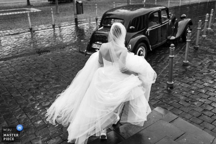 Photo by: <a href="https://www.wpja.com/contests/2019-v16/best-wedding-photographers/2561498">Paulo Sacramento - Mainz Rheinland-Pfalz</a> Germany Outdoors Photography on Wedding Day - Bride walking to the car
