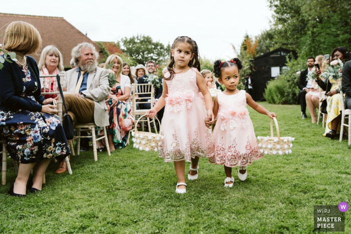 Photo by: <a href="https://www.wpja.com/contests/2019-v16/best-wedding-photographers/2562112">Karen Flower - Thames Ditton Surrey</a> Rumbolds Farm, Surrey wedding ceremony photography outdoors - flowergirls leading the way