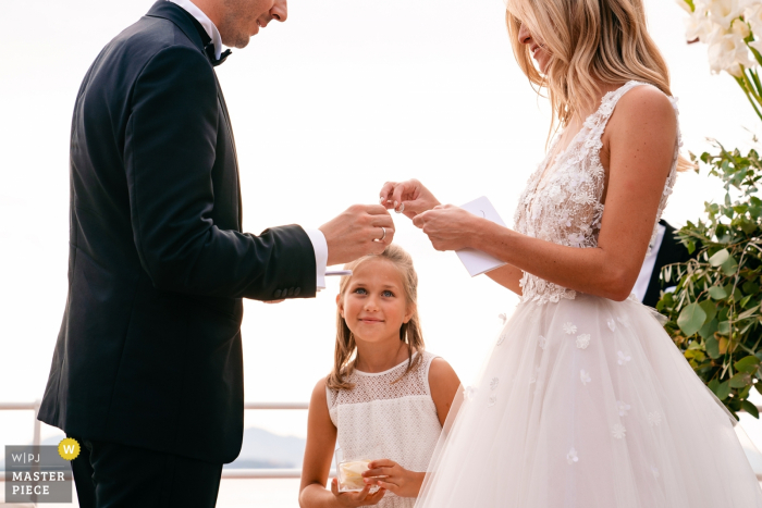 Photo by: <a href="https://www.wpja.com/contests/2019-v16/best-wedding-photographers/2562157">Yves Schepers - Bonheiden Antwerpen</a> Belgium Wedding Ceremony Photos – A Girl looks admiringly when the bride is about to put on the ring