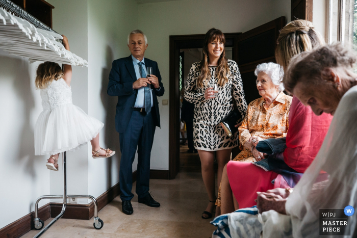 Photo by: <a href="https://www.wpja.com/contests/2019-v16/best-wedding-photographers/2562179">Fille Roelants - Antwerpen Antwerpen</a> Antwerpen Flanders Reception venue photos - picture of a kid casually hanging on a cloak hanger during the reception