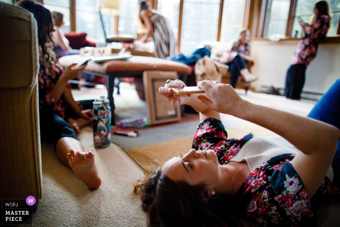 Photo by: <a href="https://www.wpja.com/contests/2019-v17/best-wedding-photographers/2562678">Trent Gillespie - Silverthorne Colorado</a> Wedding photography showing all of the bridesmaids checking their phones during bridal prep in Vail, CO.