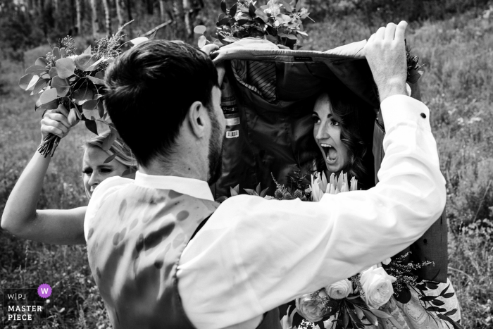 Vail, CO Fotógrafo | A noiva se escondendo de algumas gotas de chuva durante as fotos da festa de casamento.