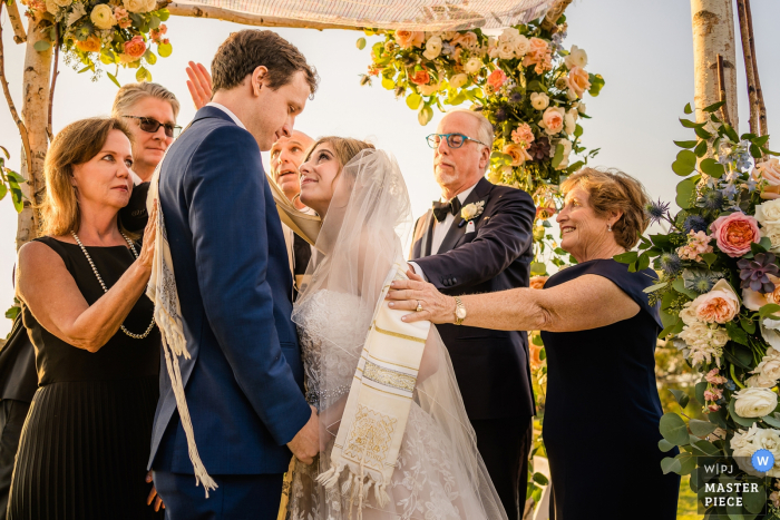 Photo by: <a href="https://www.wpja.com/contests/2019-v17/best-wedding-photographers/2562745">Kristina Cazares Neri - San Diego California</a> Del Mar, California | Couple's family blesses them during their ceremony | Wedding Photos