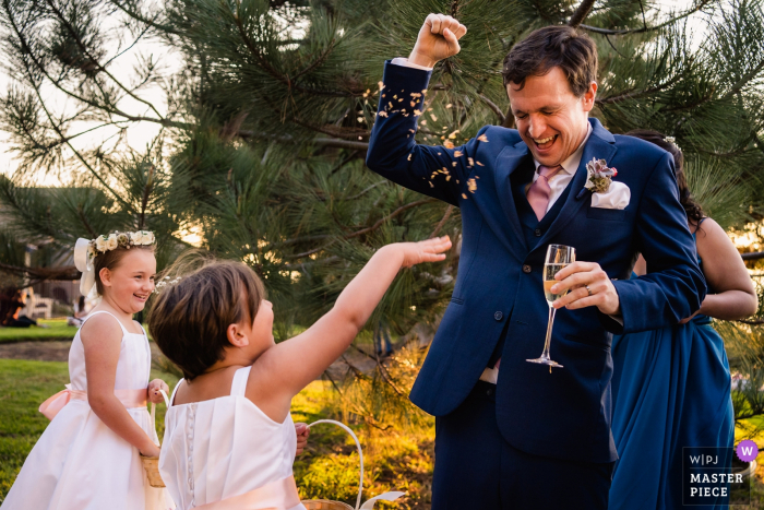 Photo by: <a href="https://www.wpja.com/contests/2019-v17/best-wedding-photographers/2562748">Kristina Cazares Neri - San Diego California</a> The wedding flower girls throw their remaining flowers at the groom - Del Mar, Ca wedding photography