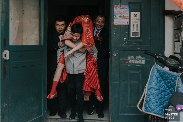 Photo by: <a href="https://www.wpja.com/contests/2019-v17/best-wedding-photographers/2562899">XiangJie Hao - Xi'an City </a> Shaanxi outdoor wedding day photography - The brother is carrying his sister out...the bride