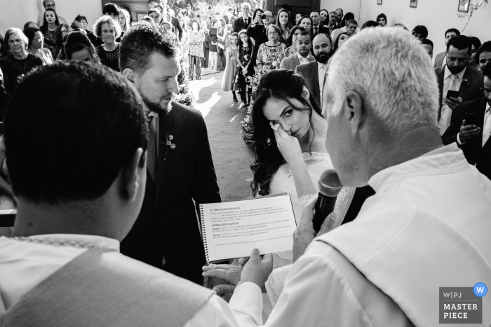Photo by: <a href="https://www.wpja.com/contests/2019-v17/best-wedding-photographers/2563506">Vinicius Terror - Ouro Preto Minas Gerais</a> Brazil Church photography from the wedding ceremony with the bride wiping a tear