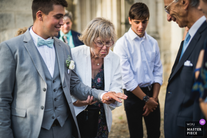 Photo by: <a href="https://www.wpja.com/contests/2019-v17/best-wedding-photographers/2563636">Franck Petit - Serignac sur Garonne </a> Agen, France wedding photograph of the groom showing off his ring to other guests after the ceremony