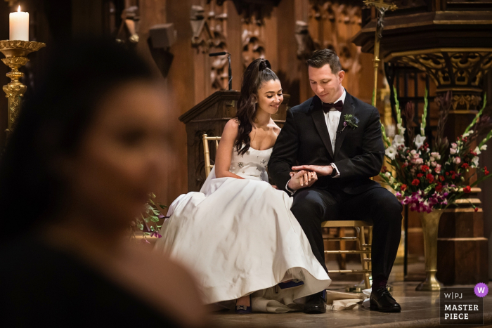 NJ Wedding Ceremony Photographer: Bride and Groom check out thier rings during communion 