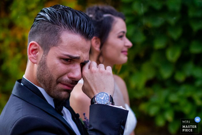 Der Bräutigam wischte sich mit seiner Braut hinter sich eine Träne ab Das Hochzeitsfoto von Lunario - Valverde zeigt die Braut, die sich eine Träne abwischt.