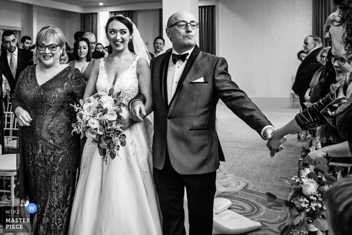 Photo by: <a href="https://www.wpja.com/contests/2019-v17/best-wedding-photographers/2563973">Michelle Arlotta - Milford New Jersey</a> Father of bride reaches out to guest as he walks bride down the aisle at Edgewood Country Club, New Jersey wedding ceremony