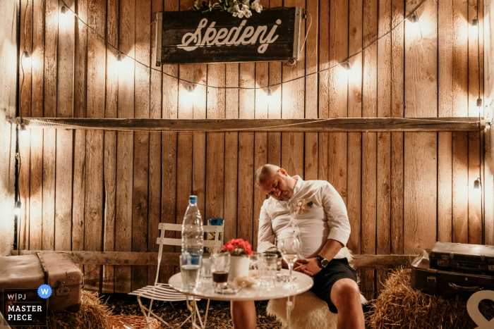 Photo by: <a href="https://www.wpja.com/contests/2019-v17/best-wedding-photographers/2564094">Goran Vadlja Kamenjašević - Velenje </a> Skedenj, Ljubljana wedding reception photography of a guest Dozing off