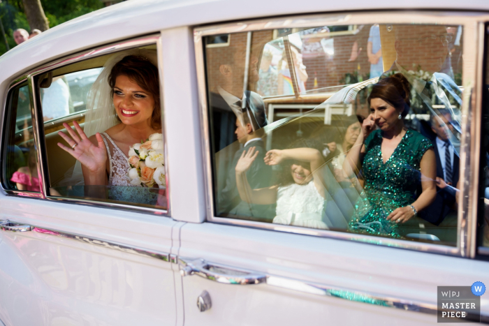 Enschede novia saludando desde el coche en esta imagen de la boda.