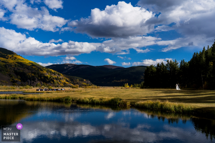 Photo by: <a href="https://www.wpja.com/contests/2019-v17/best-wedding-photographers/2564365">Brenda Bergreen - Evergreen Colorado</a> Camp Hale CO wedding venue photos under sky/clouds | Bride walking into ceremony