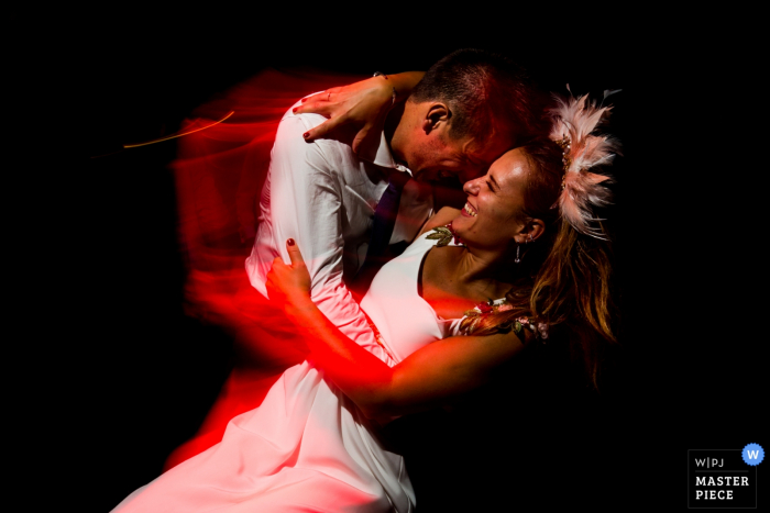 Photo by: <a href="https://www.wpja.com/contests/2019-v17/best-wedding-photographers/2564469">Miguel Onieva - Madrid Madrid</a> Spain Wedding Reception photography of the bride and groom at first dance with red light