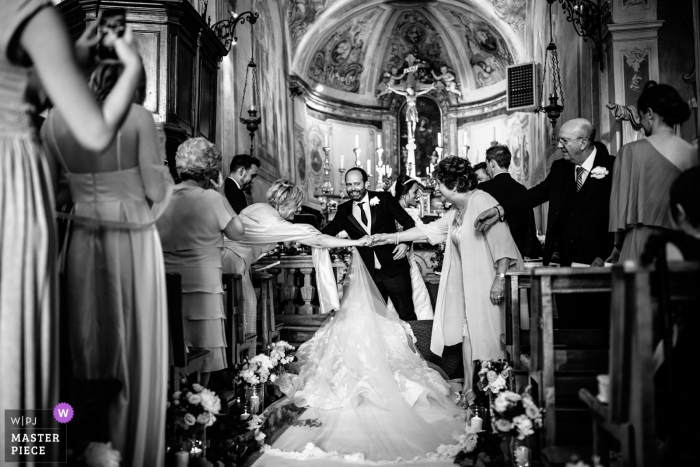 Photo by: <a href="https://www.wpja.com/contests/2019-v17/best-wedding-photographers/2564596">Fabrizio Gresti - Cairo Montenotte Savona</a> La Morra, Cuneo ceremony photography during the church wedding - bride's dress blocking guests greeting