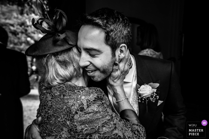 Photo by: <a href="https://www.wpja.com/contests/2019-v17/best-wedding-photographers/2564651">Paul Tansley - Bordon Hampshire</a> Wedding photography from the Ramster Hall, Chiddingfold, Surrey, UK - Groom and his mum, gentle hug full of affection and love at the venue.