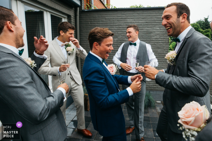 Foto von: <a href="https://www.wpja.com/contests/2019-v17/best-wedding-photographers/2564783"> Fille Roelants - Antwerpen Antwerpen </a> Antwerpen Flandern Hochzeitsreportage Fotograf - Braut- und Bräutigamshaus Groomsmen lachen in den frühen Morgenstunden mit dem verschwitzten Hemd eines Bräutigams