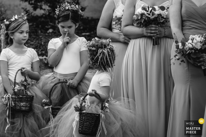 Photo by: <a href="https://www.wpja.com/contests/2019-v17/best-wedding-photographers/2564927">Nicky Byrnes - Carnelian Bay California</a> Outdoor wedding ceremony photos from venue Haue Valley: Pacific, Missouri - One flower girl shushes another during the ceremony.