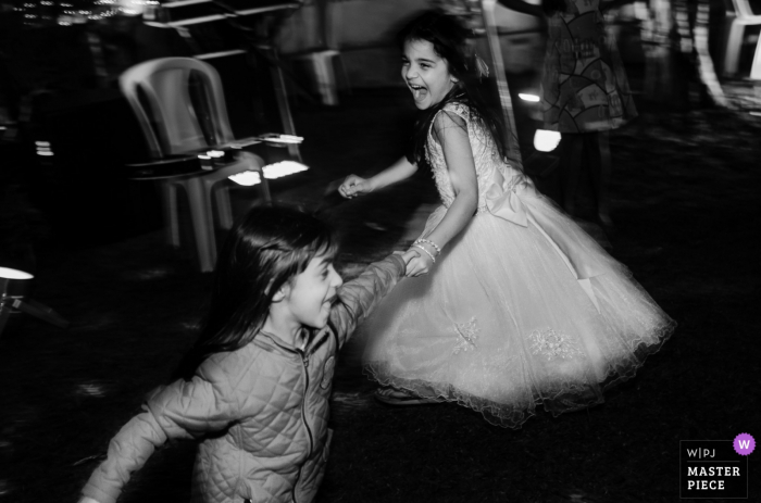 Photographie de lieu de réception de mariage au Brésil | Petite demoiselle d'honneur et son amie s'amusant pendant la soirée