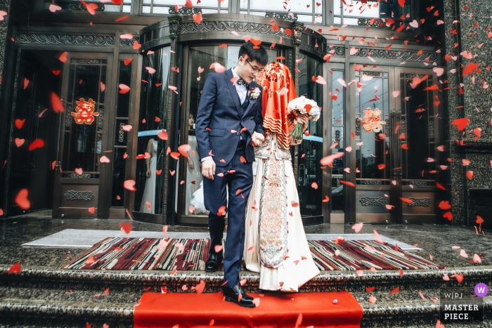 Photo by: <a href="https://www.wpja.com/contests/2019-v17/best-wedding-photographers/2565047">Wenbo Si - Zhengzhou </a> China wedding day photography : the bride was leading the man to their new life in the all around red hearts paper pieces.