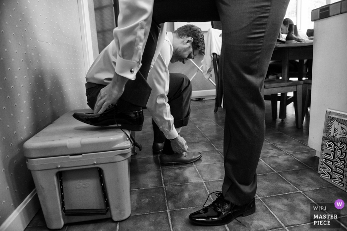 Photo by: <a href="https://www.wpja.com/contests/2019-v17/best-wedding-photographers/2565071">Matt Theilen - South Lake Tahoe California</a> Truckee, California wedding photography showing Groomsmen putting on shoes