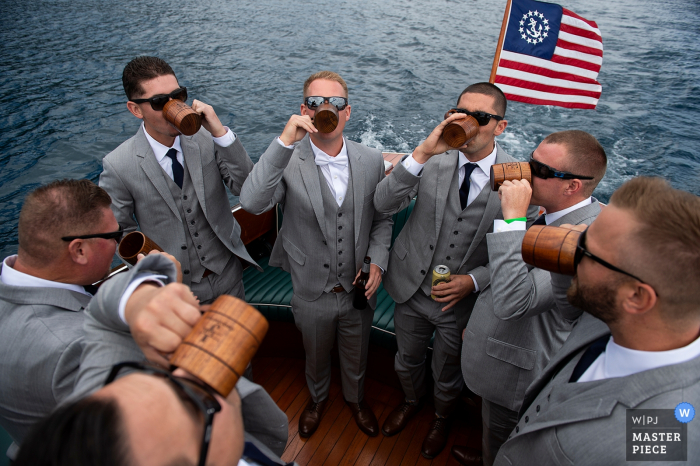 Photo by: <a href="https://www.wpja.com/contests/2019-v17/best-wedding-photographers/2565072">Matt Theilen - South Lake Tahoe California</a> Lake Tahoe, California wedding photographs : Groom and Groomsmen toasting on a boat on way to ceremony.