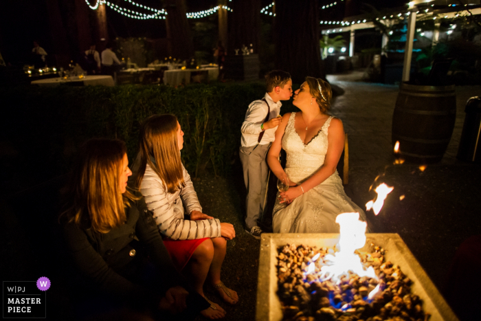 Photo by: <a href="https://www.wpja.com/contests/2019-v17/best-wedding-photographers/2565146">Chris Shum - Sunnyvale California</a> Wedding photography at Deer Park Villa, Fairfax - Picture at the outdoor fire - A sweet kiss for the bride