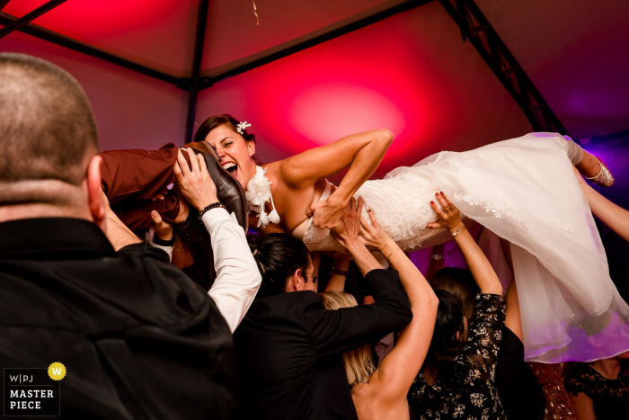 Photo by: <a href="https://www.wpja.com/contests/2019-v18/best-wedding-photographers/2566266">Sybil Rondeau - Nantes </a> Château La Forêt - The bride is carried overhead while holding onto her dress